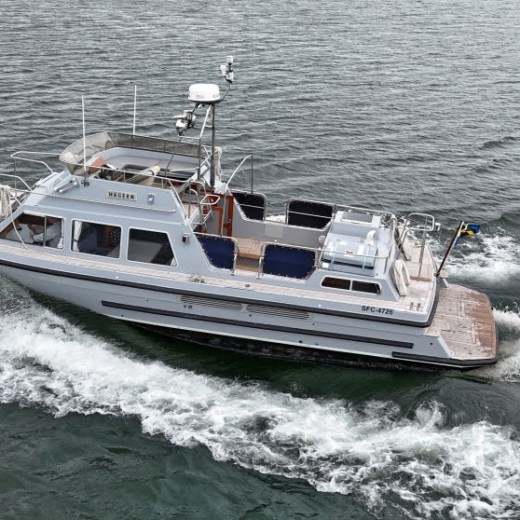A white motorboat moving swiftly across the water with waves behind it.